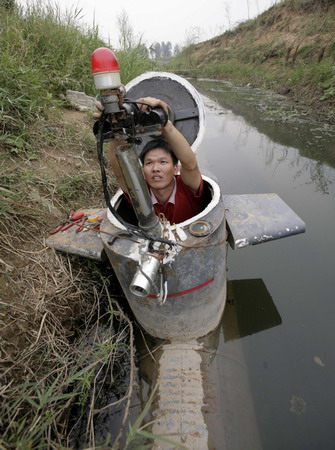 Tao Xiangli prepares his homemade submarine before operating it in a lake on the outskirts of Beijing September 3, 2009. Amateur inventor Tao, 34, made a fully functional submarine, which has a periscope, depth control tanks, electric motors, manometer, and two propellers, from old oil barrels and tools which he bought at a second-hand market. He took 2 years to invent and test the submarine which costs 30,000 yuan (US$4,385). [Agencies]